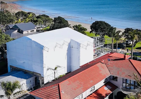 Shrink wrap weather protection installed on an Auckland construction site for winter renovation or re-roofing work | Sidewall Scaffolding